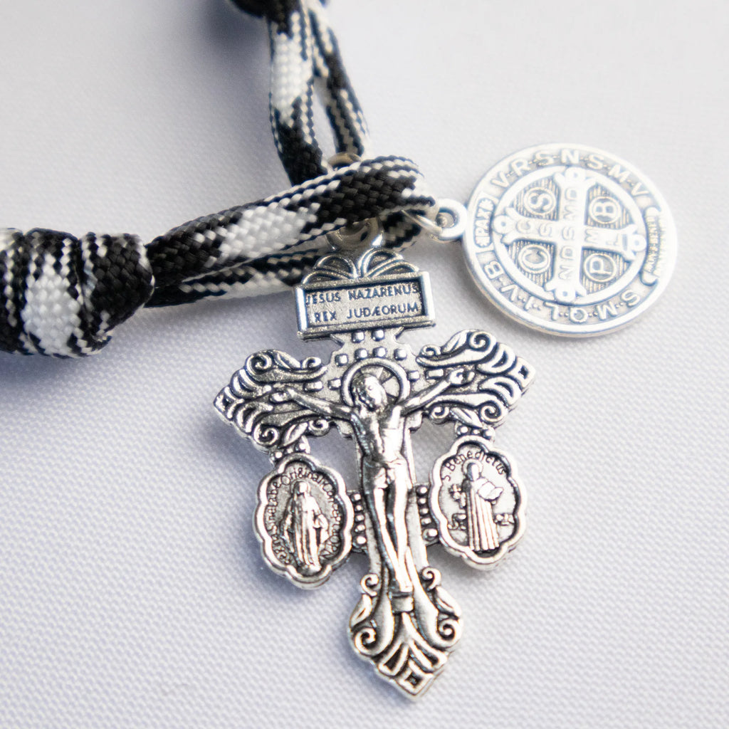 Detalle del Denario Católico Crux Invicta con cordón blanco y negro y cuentas metálicas