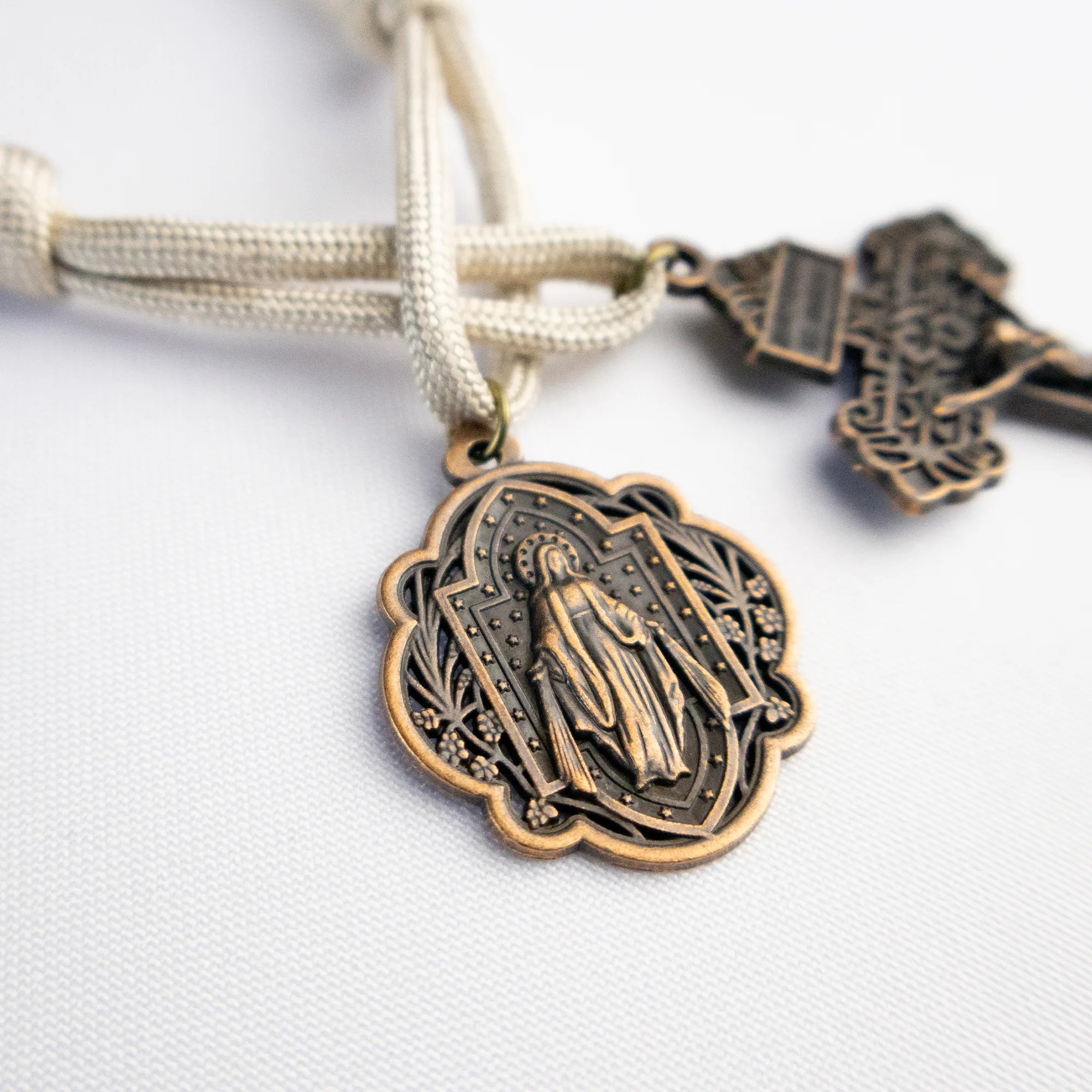 Detalle del Denario Católico Regina Coeli con medalla mariana y cruz en acabado bronce
