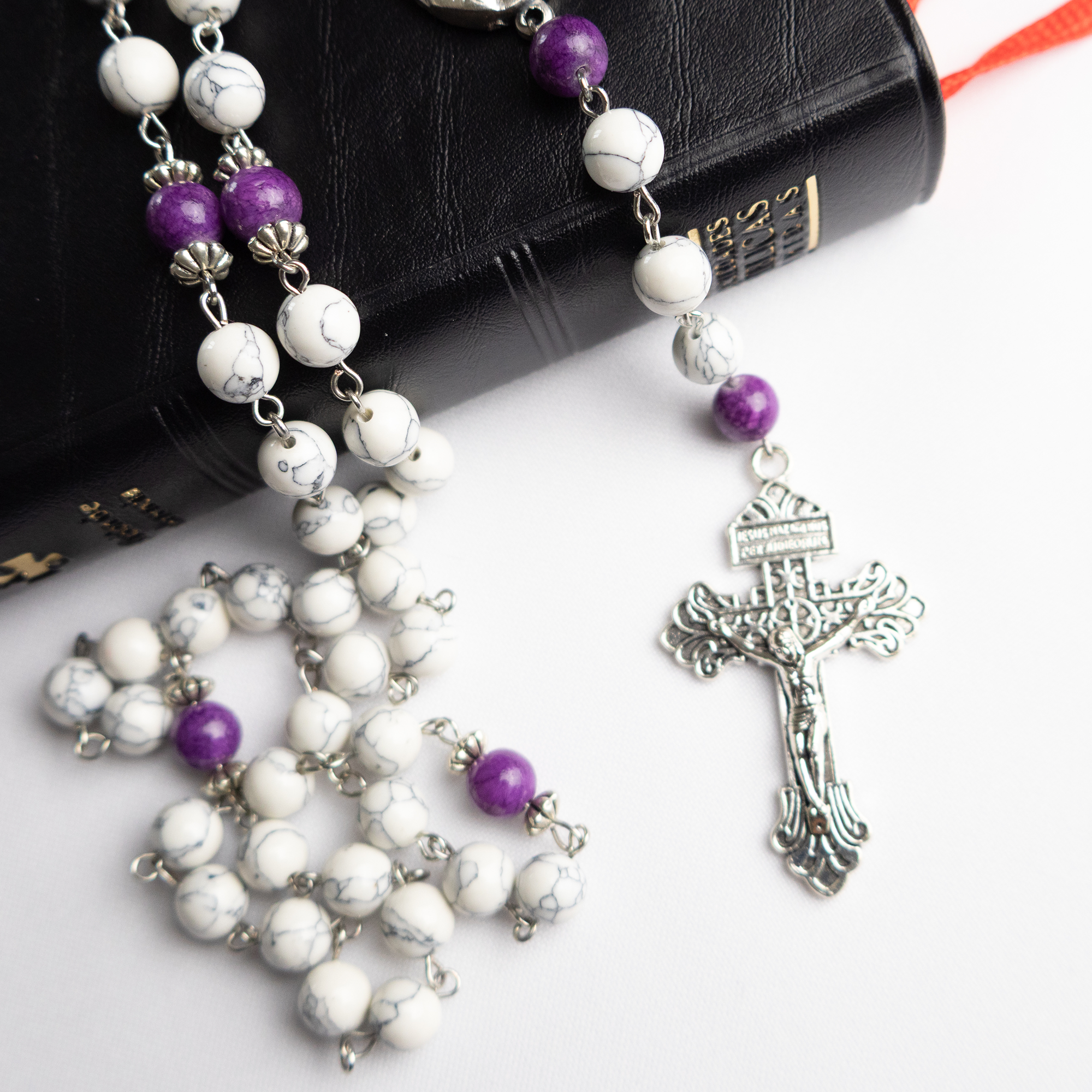 Detalle del Rosario Católico Mater Dolorosa con cuentas moradas y cruz metálica