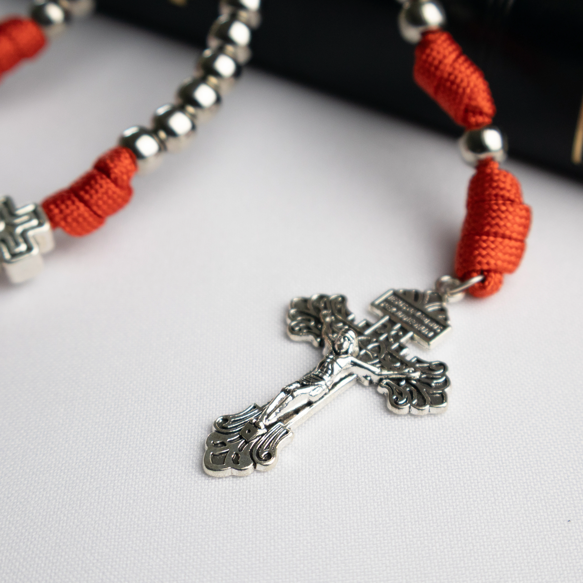Detalle del Rosario Católico Sanguis Christi con cordón paracord rojo y cruz metálica