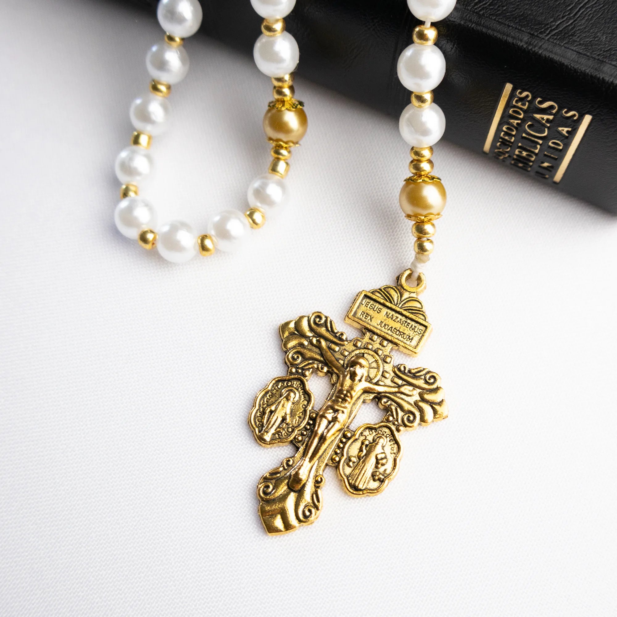 Rosario católico Maris Stella extendido sobre fondo blanco